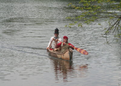 Voyageurs paddling their birch bark canoe.